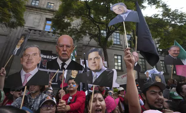 FILE - Justice employees hold up cutouts of Supreme Court justices in a show of support as they discuss a draft ruling that proposes the partial invalidation of the judicial reform approved by Congress, in Mexico City, Nov. 5, 2024. (AP Photo/Fernando Llano, File)