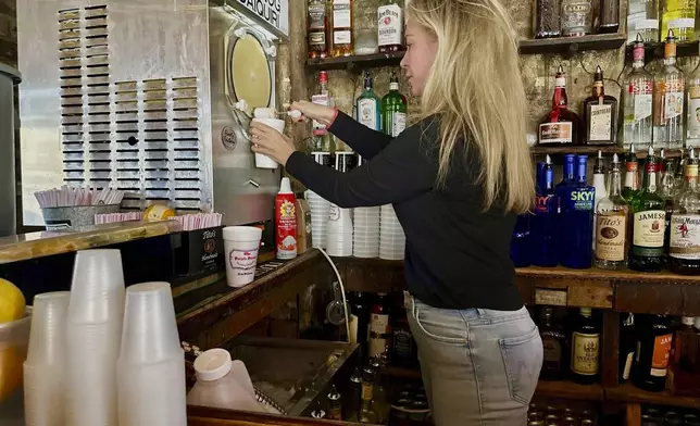 Jamie Gourgues, marketing manager of Lafitte's Blacksmith Shop, prepares an eggnog daiquiri in New Orleans on Thursday, Dec. 12, 2024. (AP Photo/Stephen Smith)