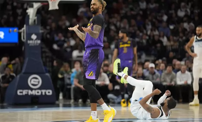 Los Angeles Lakers guard D'Angelo Russell, left, reacts after being called for a foul during the first half of an NBA basketball game against the Minnesota Timberwolves, Monday, Dec. 2, 2024, in Minneapolis. (AP Photo/Abbie Parr)