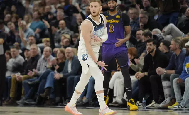 Minnesota Timberwolves guard Donte DiVincenzo (0) reacts next to Los Angeles Lakers forward Anthony Davis (3) after making a 3-point shot during the first half of an NBA basketball game, Monday, Dec. 2, 2024, in Minneapolis. (AP Photo/Abbie Parr)