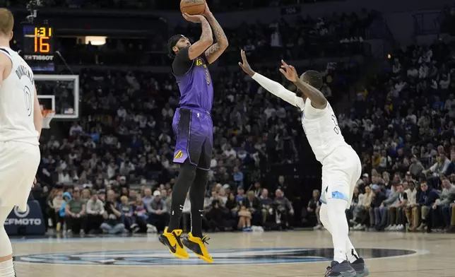 Los Angeles Lakers forward Anthony Davis (3), left, shoots over Minnesota Timberwolves forward Julius Randle (30) during the first half of an NBA basketball game, Monday, Dec. 2, 2024, in Minneapolis. (AP Photo/Abbie Parr)