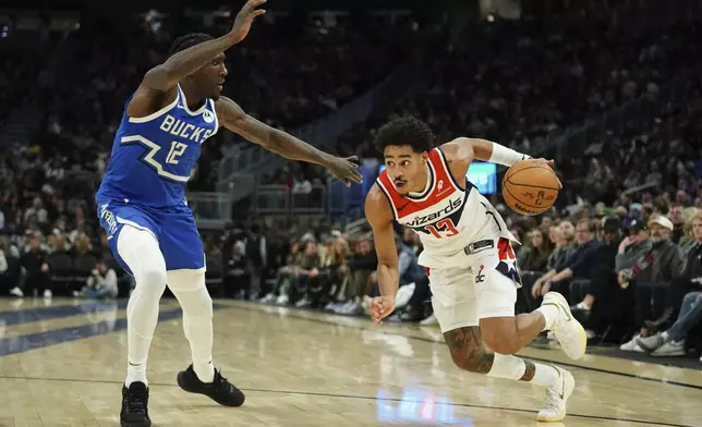 Washington Wizards' Jordan Poole (13) drives to the basket against Milwaukee Bucks' Taurean Prince (12) during the first half of an NBA basketball game Saturday, Nov. 30, 2024, in Milwaukee. (AP Photo/Aaron Gash)