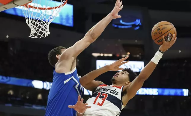 Washington Wizards' Jordan Poole (13) shoots against Milwaukee Bucks' Brook Lopez during the first half of an NBA basketball game Saturday, Nov. 30, 2024, in Milwaukee. (AP Photo/Aaron Gash)