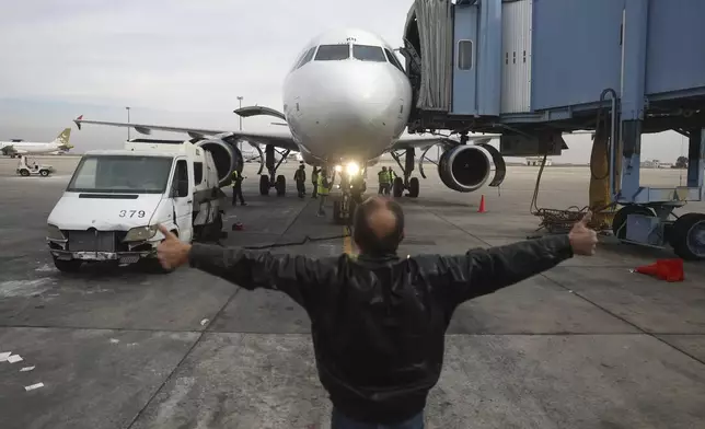 Airport staff work on the maintenance of an aircraft at the Damascus international airport Dec. 11, 2024. (AP Photo/Ghaith Alsayed)