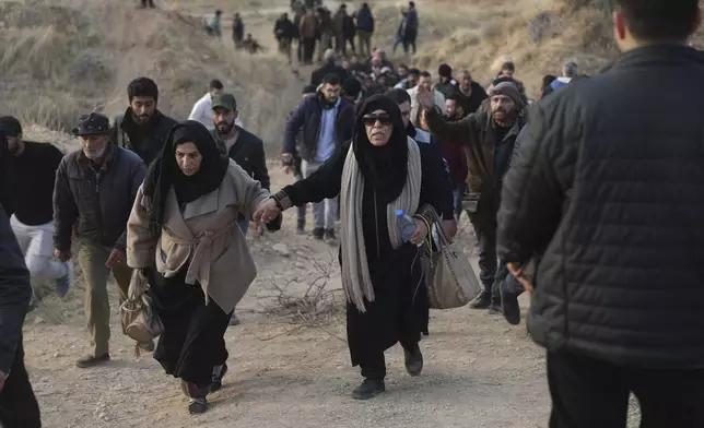 People walk towards the infamous Saydnaya military prison, just north of Damascus, Syria, Monday, Dec. 9, 2024, after thousands of inmates were released following the rebels' overthrow of Bashar al-Assad's regime on Sunday. (AP Photo/Ghaith Alsayed)