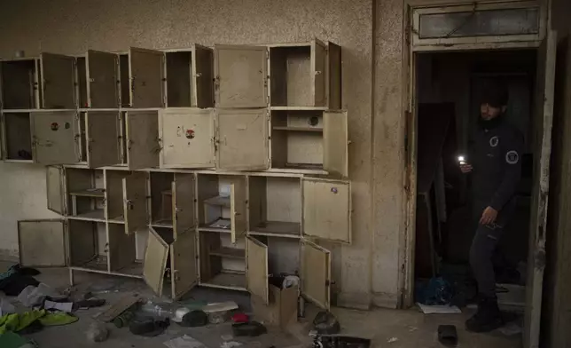 A police officer from Idlib shows a room of a damaged police station in the Bab Touma neighborhood of the Old City of Damascus, Syria, Saturday, Dec. 14, 2024. (AP Photo/Leo Correa)