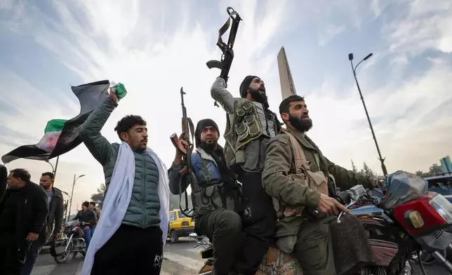 FILE - Syrian opposition fighters celebrate after the Syrian government collapsed in Damascus, Syria, Sunday, Dec. 8, 2024. (AP Photo/Omar Sanadiki, File)