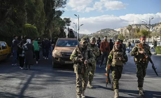 FILE - Syrian fighters walk to attend a celebratory demonstration following the first Friday prayers since Bashar Assad's ouster, in Damascus' central square, Syria, Friday, Dec. 13, 2024. (AP Photo/Leo Correa, File)