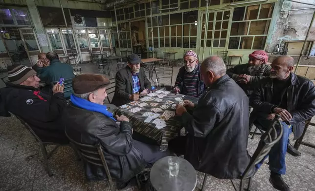 FILE - People play cards at a café in Damascus, Syria, on Tuesday, Dec. 10, 2024. (AP Photo/Hussein Malla, File)