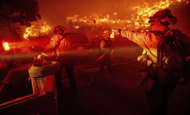 Firefighters battle the Franklin Fire in Malibu, Calif., on Tuesday, Dec. 10, 2024. (AP Photo/Ethan Swope)