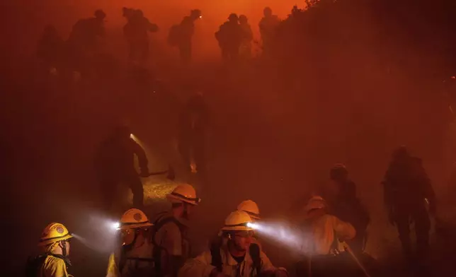 Firefighters battle the Franklin Fire in Malibu, Calif., on Tuesday, Dec. 10, 2024. (AP Photo/Ethan Swope)