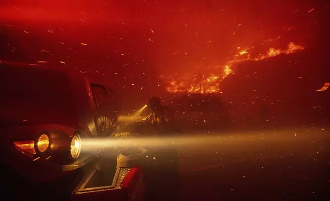 Firefighters battle the Franklin Fire in Malibu, Calif., on Tuesday, Dec. 10, 2024. (AP Photo/Ethan Swope)