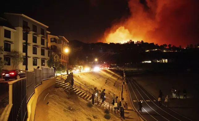 Students evacuate from Pepperdine University as the Franklin Fire burns in Malibu, Calif., on Tuesday, Dec. 10, 2024. (AP Photo/Ethan Swope)