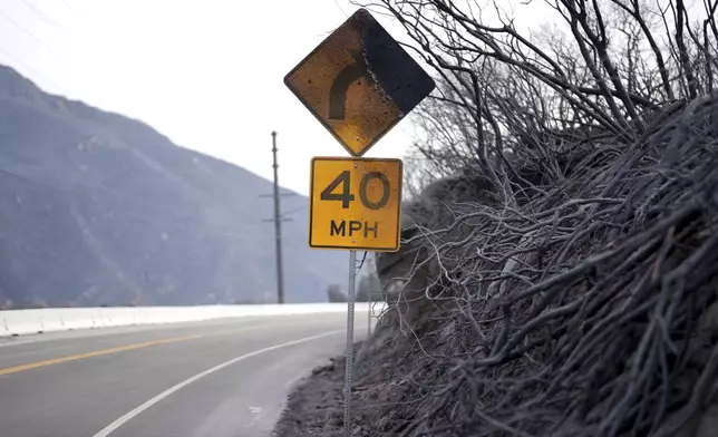 A road signed is burned after the Franklin Fire swept through Wednesday, Dec. 11, 2024, in Malibu, Calif. (AP Photo/Eric Thayer)