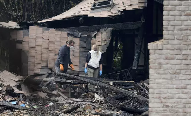 Resident sift through their fire-damage property after the Franklin Fire swept through Wednesday, Dec. 11, 2024, in Malibu, Calif. (AP Photo/Damian Dovarganes)