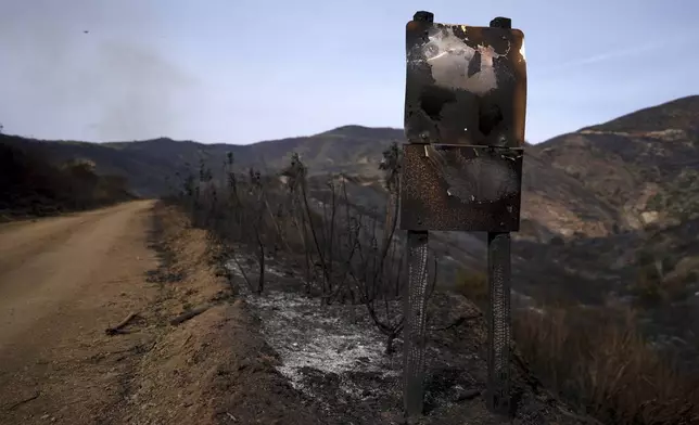 A road signed is burned after the Franklin Fire swept through Wednesday, Dec. 11, 2024, in Malibu, Calif. (AP Photo/Eric Thayer)