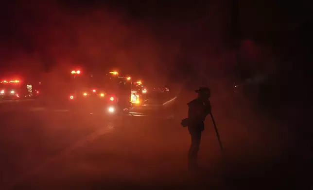 A firefighter watches the Franklin Fire as smoke fills the air in Malibu, Calif., Tuesday, Dec. 10, 2024. (AP Photo/Jae C. Hong)