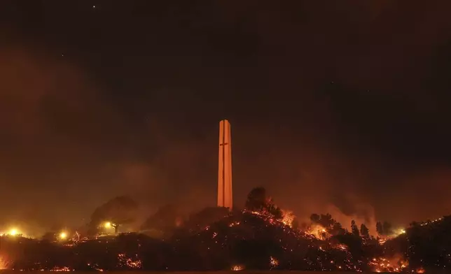 Vegetation around the Phillips Theme Tower at Pepperdine University is scorched by the Franklin Fire in Malibu, Calif., Tuesday, Dec. 10, 2024. (AP Photo/Jae C. Hong)