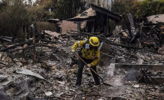 A firefighter works at a home devastated by the Franklin Fire in Malibu, Calif., Wednesday, Dec. 11, 2024. (AP Photo/Jae C. Hong)