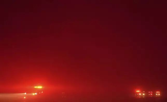 Fire trucks are parked along Pacific Coast Highway as smoke from the Franklin Fire fills the air in Malibu, Calif., Tuesday, Dec. 10, 2024. (AP Photo/Jae C. Hong)