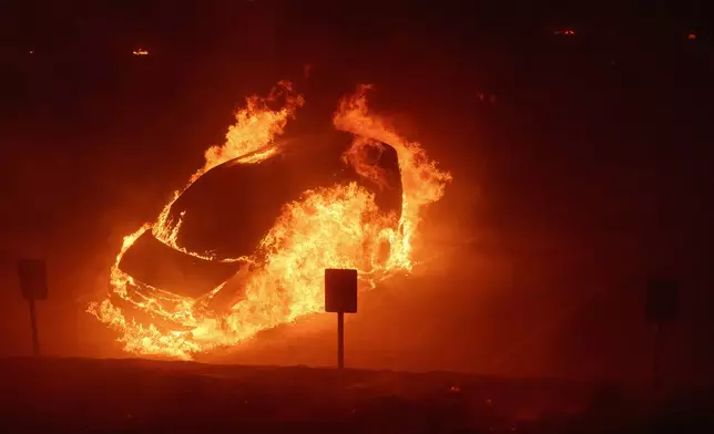 A vehicle burns during the Franklin Fire on the campus of Pepperdine University in Malibu, Calif., Tuesday, Dec. 10, 2024. (AP Photo/Eric Thayer)