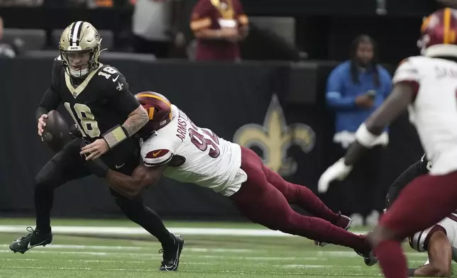 Washington Commanders defensive end Dorance Armstrong (92) sacks New Orleans Saints quarterback Spencer Rattler (18) in the second half of an NFL football game in New Orleans, Sunday, Dec. 15, 2024. (AP Photo/Gerald Herbert)