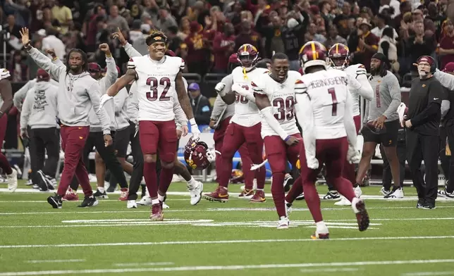 The Washington Commanders celebrate a win against the New Orleans Saints after an NFL football game in New Orleans, Sunday, Dec. 15, 2024. (AP Photo/Gerald Herbert)