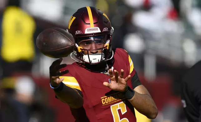 Washington Commanders quarterback Jayden Daniels (5) throwing the ball before the start of an NFL football game against the Philadelphia Eagles, Sunday, Dec. 22, 2024, in Landover, Md. (AP Photo/Nick Wass)