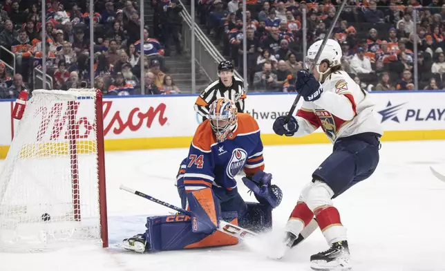 Florida Panthers' Jesper Boqvist, right, scores against Edmonton Oilers goalie Stuart Skinner (74) during first-period NHL hockey game action in Edmonton, Alberta, Monday, Dec. 16, 2024. (Jason Franson/The Canadian Press via AP)