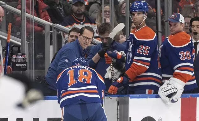 Edmonton Oilers' Zach Hyman (18) is injured after taking a puck to the face on a shot by a teammate during second-period NHL hockey game action against the Florida Panthers in Edmonton, Alberta, Monday, Dec. 16, 2024. (Jason Franson/The Canadian Press via AP)