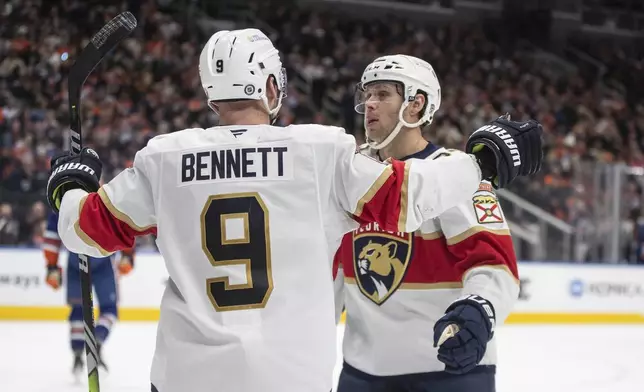 Florida Panthers' Sam Bennett (9) and Carter Verhaeghe, right, celebrate after a goal against the Edmonton Oilers during third-period NHL hockey game action in Edmonton, Alberta, Monday, Dec. 16, 2024. (Jason Franson/The Canadian Press via AP)