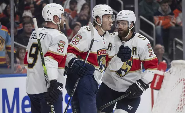 Florida Panthers' Sam Bennett (9), Matthew Tkachuk (19) and Aaron Ekblad (5) celebrate after a goal against the Edmonton Oilers during first-period NHL hockey game action in Edmonton, Alberta, Monday, Dec. 16, 2024. (Jason Franson/The Canadian Press via AP)