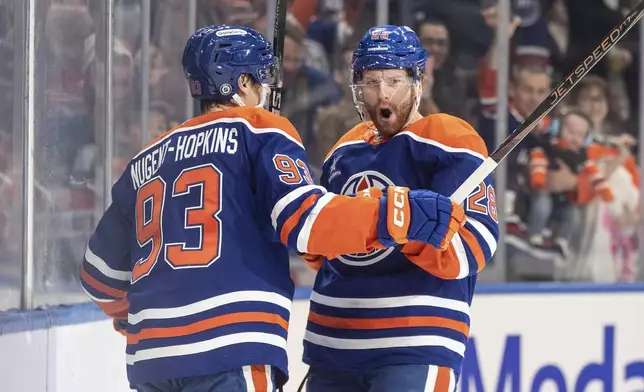 Edmonton Oilers' Ryan Nugent-Hopkins (93) and Connor Brown (28) celebrate after a goal against the Florida Panthers during second-period NHL hockey game action in Edmonton, Alberta, Monday, Dec. 16, 2024. (Jason Franson/The Canadian Press via AP)