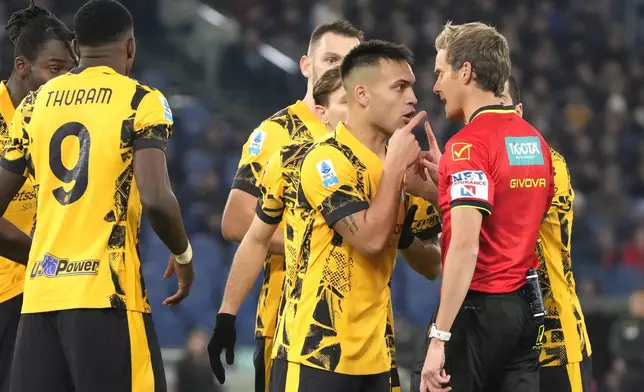 Inter Milan players argue with referee Daniele Chiffi, right, during the Italian Serie A soccer match between Lazio and Inter at Rome's Olympic Stadium, Rome, Italy, Monday, Dec. 16, 2024. (AP Photo/Gregorio Borgia)