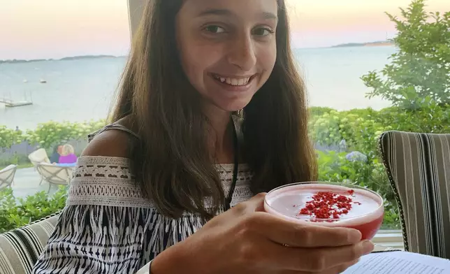 This July 1, 2019 photo shows Lauren Minichiello, 11, holding a Rose Martini mocktail at a restaurant in Harwich, Mass. (Erin Minichiello via AP)