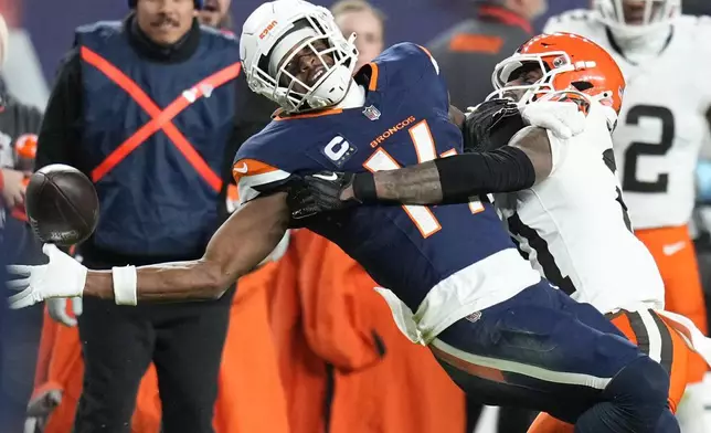 Denver Broncos wide receiver Courtland Sutton (14) is defended by Cleveland Browns cornerback Denzel Ward (21) during the second half of an NFL football game, Monday, Dec. 2, 2024, in Denver. (AP Photo/Jack Dempsey)