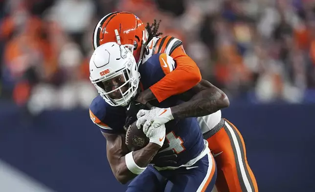 Denver Broncos wide receiver Courtland Sutton (14) is tackled by Cleveland Browns cornerback Martin Emerson Jr. during the first half of an NFL football game, Monday, Dec. 2, 2024, in Denver. (AP Photo/David Zalubowski)