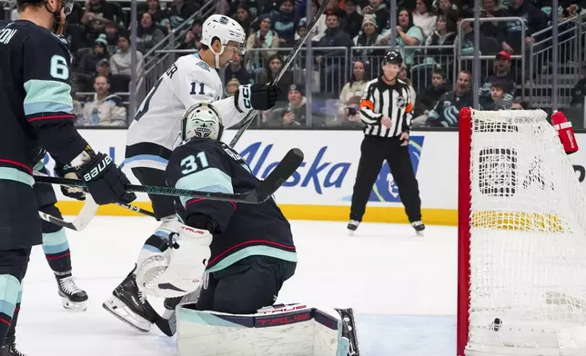 Utah Hockey Club right wing Dylan Guenther (11) reacts as a goal by center Logan Cooley (not pictured) goes into the net past Seattle Kraken goaltender Philipp Grubauer (31) during the first period of an NHL hockey game Monday, Dec. 30, 2024, in Seattle. (AP Photo/Lindsey Wasson)