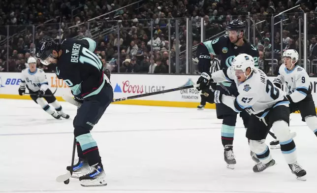 Seattle Kraken center Matty Beniers is hooked by Utah Hockey Club center Barrett Hayton, right, during the first period of an NHL hockey game Monday, Dec. 30, 2024, in Seattle. (AP Photo/Lindsey Wasson)