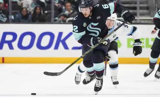 Seattle Kraken defenseman Brandon Montour moves the puck against Utah Hockey Club center Clayton Keller, back, during the second period of an NHL hockey game Monday, Dec. 30, 2024, in Seattle. (AP Photo/Lindsey Wasson)