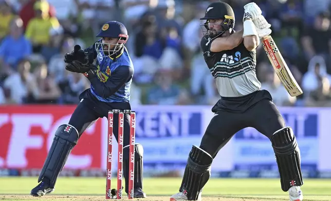 New Zealand's Tim Robinson plays a shot as Sri Lanka's Kusal Mendis looks on, during the second Twenty20 international cricket match between New Zealand and Sri Lanka at Mt. Maunganui, New Zealand Monday, Dec. 30, 2024. (Andrew Cornaga/Photosport via AP)