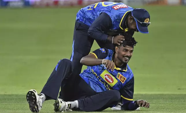 Sri Lanka's Charith Asalanka and Binura Fernando celebrate the run out of New Zealand's Daryl Mitchell, during the second Twenty20 international cricket match between New Zealand and Sri Lanka at Mt. Maunganui, New Zealand Monday, Dec. 30, 2024. (Andrew Cornaga/Photosport via AP)