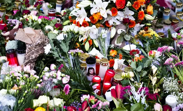 Flowers and candles laid down in front of the Johannis church close to the Christmas market, where a car drove into a crowd on Friday evening, in Magdeburg, Germany, Sunday, Dec. 22, 2024. (AP Photo/Ebrahim Noroozi)