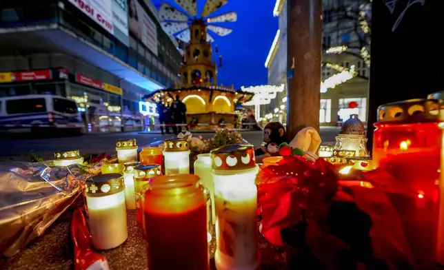 People have lit candles at the Christmas Market in Magdeburg, Germany on Saturday evening , Dec. 21, 2024, where a car drove into a crowd on Friday evening, . (AP Photo/Michael Probst)