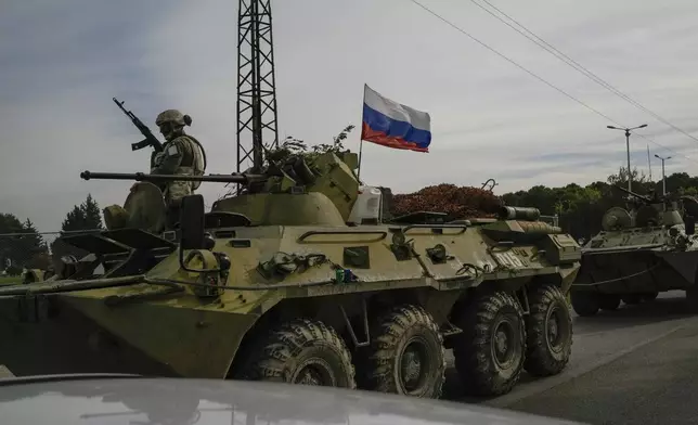 Russian army armoured vehicles drive near the Hmeimim Air Base, a Syrian airbase currently operated by Russia, located southeast of the city of Latakia in the town of Hmeimim, Syria, Monday Dec. 16, 2024.(AP Photo/Leo Correa)