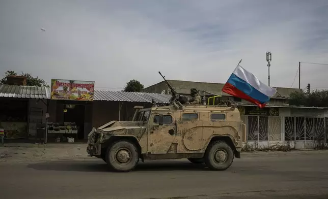 A Russian military vehicle drives toward the Hmeimim Air Base, a Syrian airbase currently operated by Russia, located southeast of the city of Latakia in the town of Hmeimim, Syria, Monday Dec. 16, 2024.(AP Photo/Leo Correa)