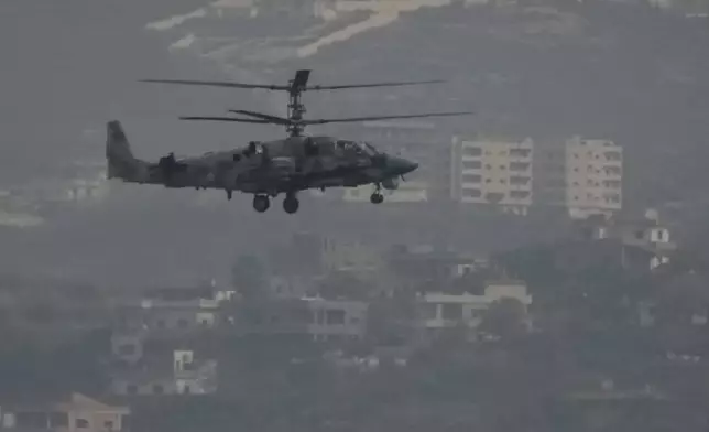 A Russian helicopter flies over the Hmeimim Air Base, a Syrian airbase currently operated by Russia, located southeast of the city of Latakia in the town of Hmeimim, Syria, on Monday, Dec.16, 2024. (AP Photo/Leo Correa)