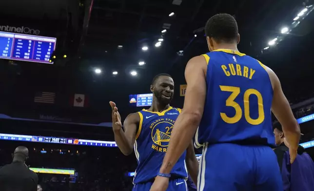 Golden State Warriors guard Stephen Curry (30) is congratulated by forward Andrew Wiggins, left, after making a basket to end the first half of an NBA basketball game against the Phoenix Suns, Saturday, Dec. 28, 2024, in San Francisco. (AP Photo/Godofredo A. Vásquez)