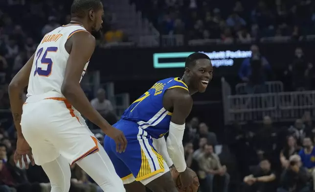 Golden State Warriors guard Dennis Schroder, right, looks to pass the ball while defended by Phoenix Suns forward Kevin Durant, left, during the first half of an NBA basketball game Saturday, Dec. 28, 2024, in San Francisco. (AP Photo/Godofredo A. Vásquez)