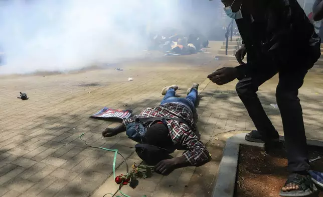 A man lies down on the ground after being tear-gassed by police during a protests against abductions dubbed "End Protests" in Nairobi, Kenya, Monday, Dec. 30, 2024. (AP Photo/Andrew Kasuku)